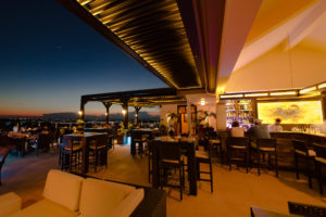 An image of a outdoor space of a restaurant covered by a louvered roof