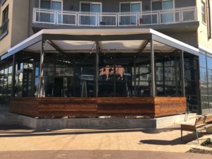 An image of a restaurant's patio covered by Apollo's louvered roof