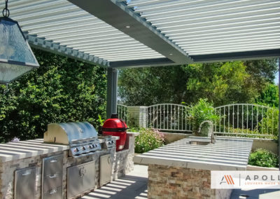 Freestanding smart pergola featuring outdoor kitchen with gas and charcoal BBQs, counterspace, & sink.