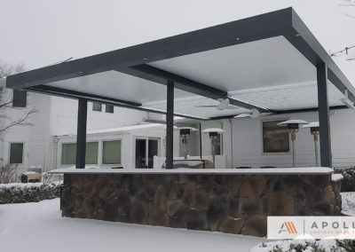 Cantilivered louvered pergola with integrated heaters and fans, half open, half closed on snowy day.
