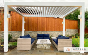 Freestanding adjustable pergola in white covering outdoor entertainment area.