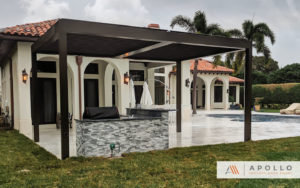 Two-bay Apollo louvered pergola in all bronze color, covering outdoor BBQ and cooking area.