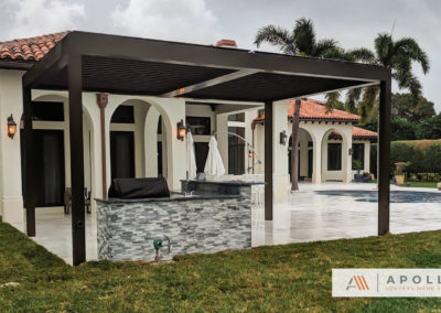 Two-bay Apollo louvered pergola in all bronze color, covering outdoor BBQ and cooking area.