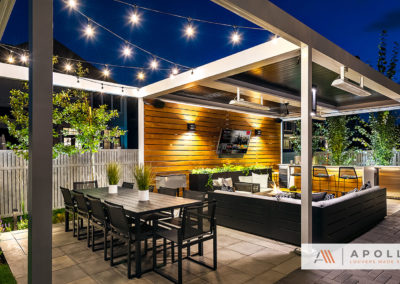 Contemporary motorized pergola w/ heaters, fans covers outdoor entertainment area w/ TV, fireplace, BBQ & seating.
