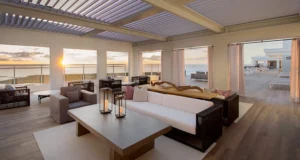 Sunset view of fully integrated louvered roof system in a commercial hospitality space.