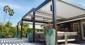Energy-efficient wall attached multi-tier louvered pergola over an outdoor entertainment area.