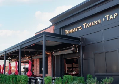 Black louvered pergola at Tommy’s Tavern and Tap House, New Jersey, providing comfortable outdoor dining for guests.