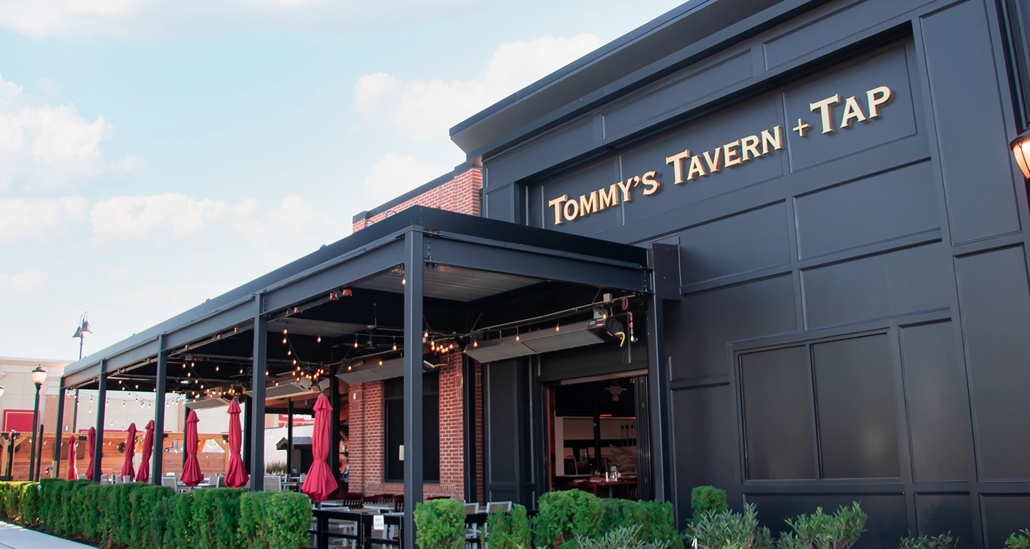 Black louvered pergola at Tommy’s Tavern and Tap House, New Jersey, providing comfortable outdoor dining for guests.
