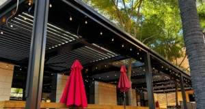 Louvered pergola with custom bronze framing at Back Bistro, Folsom, CA. Heaters, fans, and lights add ambiance.