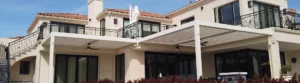 Elegant luxury home showcasing a white louvered pergola installation over the patio area
