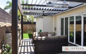 Modern louvered pergola by Apollo enhancing a cozy patio area with sunlight filtering through.