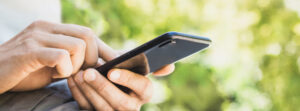 Person using a smartphone to control a smart pergola system, showcasing the ease of home automation.