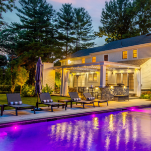 Modern outdoor patio with a pergola featuring recessed LED lights and pool lighting.