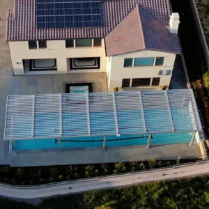 Pergola installed over a swimming pool, providing shade and sun protection.
