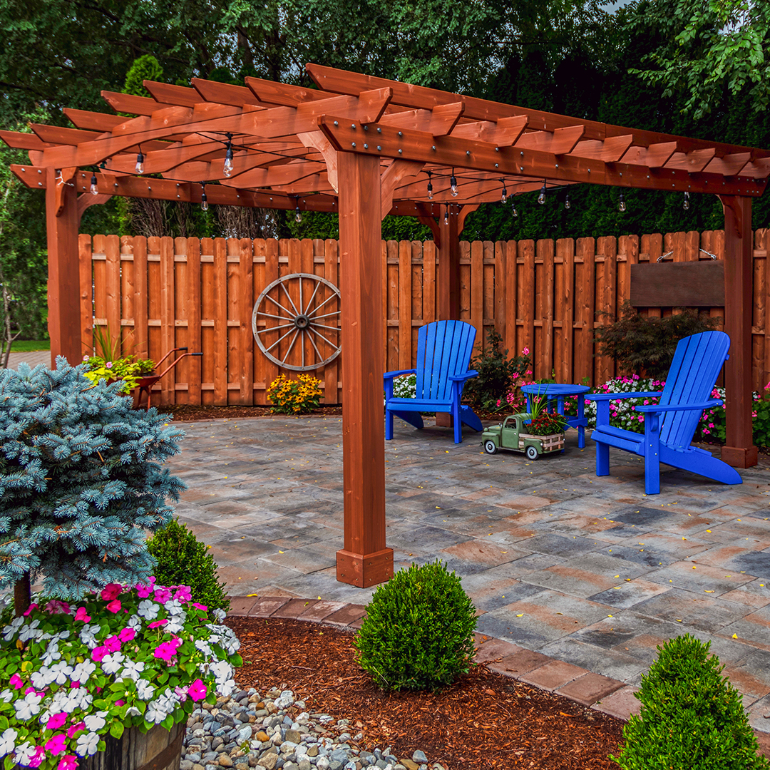 Wooden pergola over patio with blue chairs and garden decor