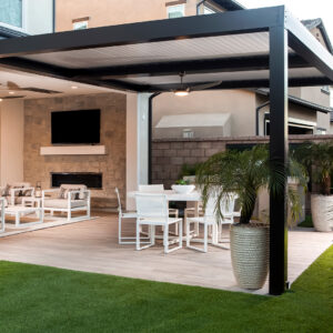 Modern covered patio with TV, fireplace, white dining set, and potted palms