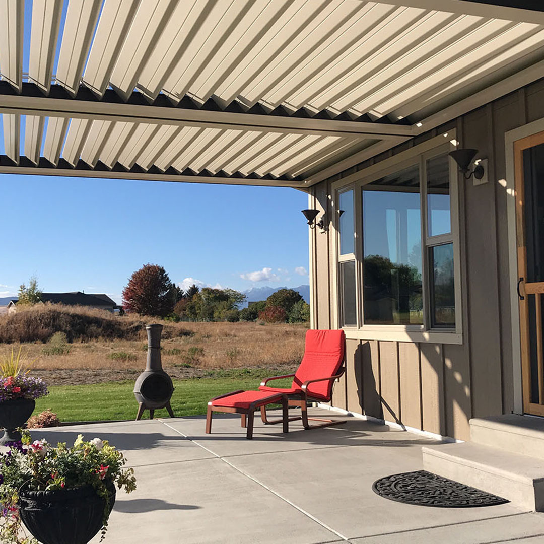 Rural Patio with Lounge Chair and Cover Backyard patio with louvered cover, red lounge chair, and open field view