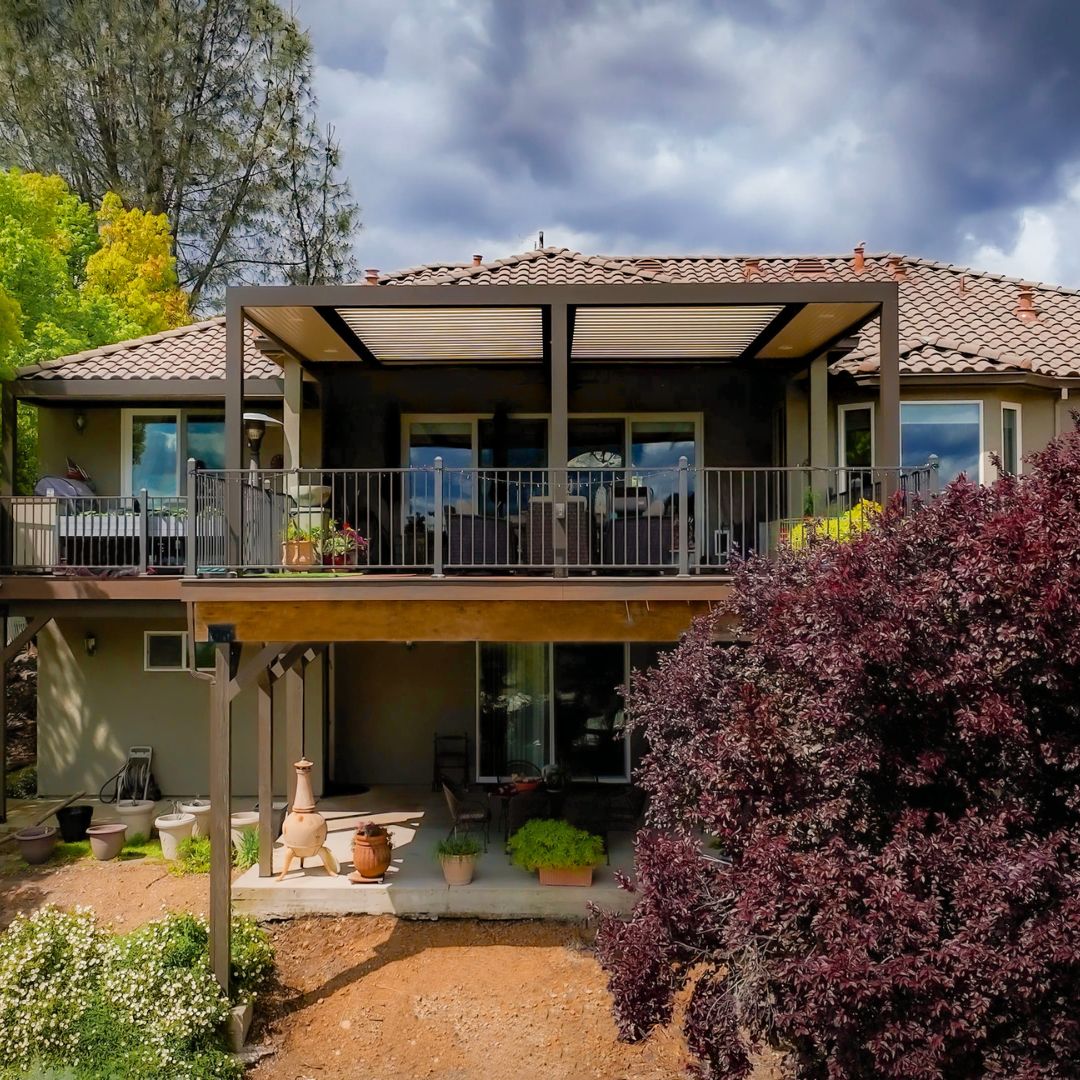 Home with Louvered Roof Deck and Garden Two-story home with louvered roof over upper deck and garden below