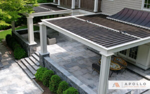 Elegant stone patio with Apollo louvered pergola and outdoor seating