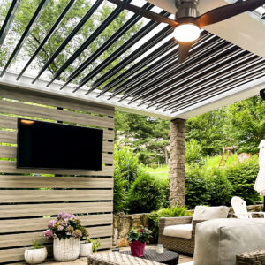 Covered patio with louvered pergola, media wall, and outdoor seating