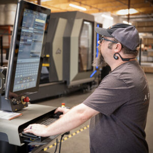 Apollo Opening Roof technician operating a CNC machine at the Northern California manufacturing facility