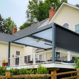 Dark aluminum louvered pergola with open louvers, a deployed motorized side screen, ceiling fan, and integrated LED lighting on an elevated residential deck